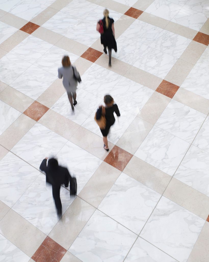 Elevated view of blurred business people walking on tiled floor
